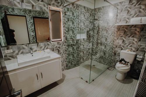 a bathroom with a sink and a toilet and a shower at Segara Residencias in Olongapo