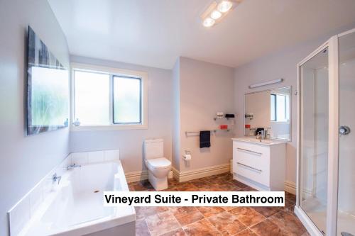 a bathroom with a tub and a toilet and a sink at Grey Ridge Vineyard Experience in Alexandra