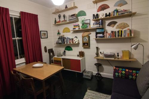 a room with a table and a kitchen with shelves at Piccolo in Leura
