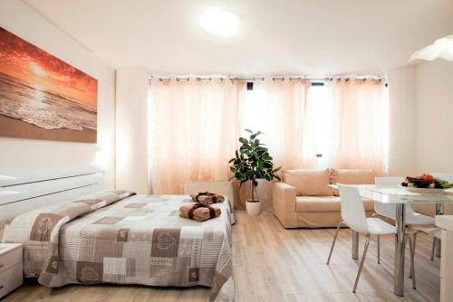 a white bedroom with a bed and a table at Residence Ferrucci in Prato