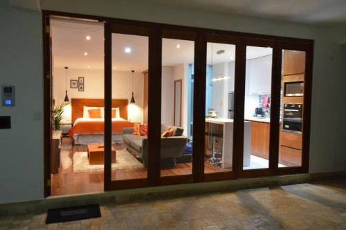 a living room with a large glass door with a bedroom at Z&R HOME in Huaraz