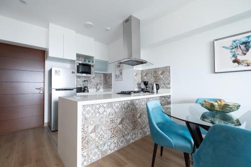 una cucina e una sala da pranzo con tavolo e sedie blu di GLOBALSTAY - Exclusive Modern Barranco Apartments a Lima