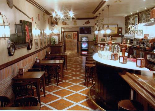 a bar with wooden tables and chairs in a restaurant at Hostal El Jardín in Benidorm