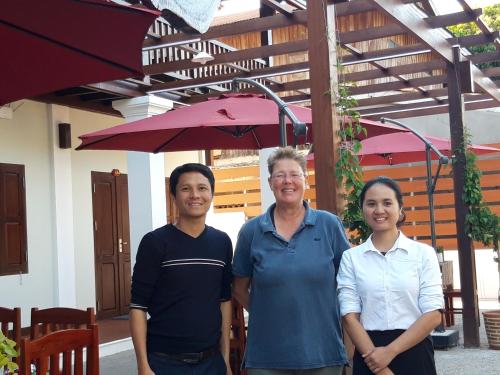 a group of three people standing in front of a building at Villa Chitchareune 2 in Luang Prabang