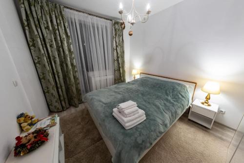 um quarto com uma cama grande e um cobertor azul em Green FOREST Resort Colina Marei em Sinaia