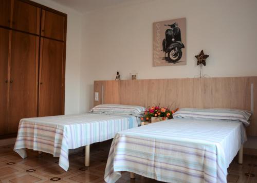 two beds with striped sheets in a room at Ca'n Pedro in Sa Coma
