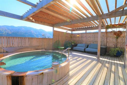 a hot tub on a deck with a pergola at 旅乃家 宇佐美温泉 海ホテル 本館ーアネックス館 in Ito