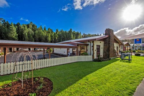 a house with a white fence and a yard at Gold Rush Inn in Queenstown