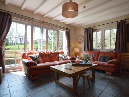 uma sala de estar com um sofá e uma mesa em Holiday home in the middle of nature with sauna em Longfaye