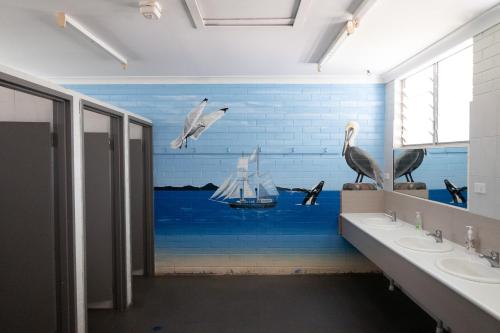 a bathroom with a mural of birds and a boat at Rockhampton Backpackers YHA in Rockhampton