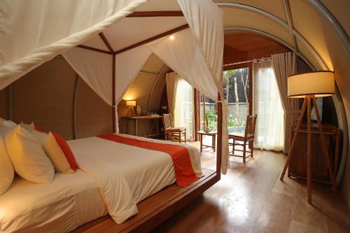 um quarto com uma cama de dossel num quarto em Templation Hotel em Siem Reap