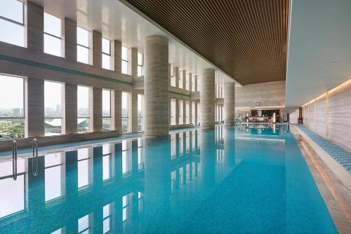 a swimming pool with blue water in a building at Pullman Wuxi New Lake in Wuxi