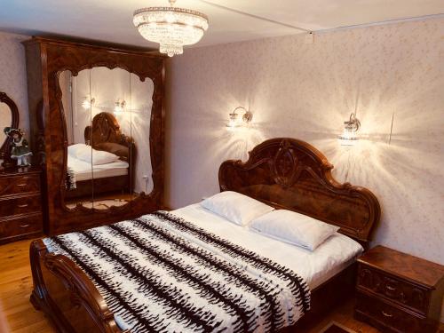 a bedroom with a large bed and two mirrors at Pokrovsky Guest House in Suzdal