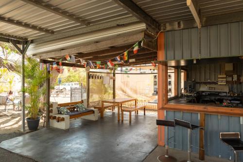 a patio with a table and a kitchen with flags at Rockhampton Backpackers in Rockhampton