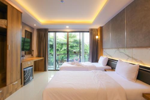 a hotel room with two beds and a fireplace at The Mantra Hotel Kata Noi in Kata Beach