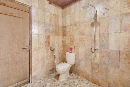 a bathroom with a toilet and a shower at RedDoorz at Omah Kayu Homestay Yogyakarta in Yogyakarta