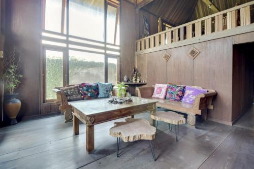 a living room with a wooden table and a couch at RedDoorz at Omah Kayu Homestay Yogyakarta in Yogyakarta