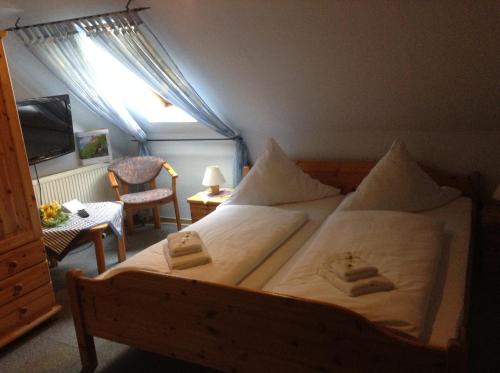 a bedroom with a bed with two towels on it at Hotel Mühleneck in Hage