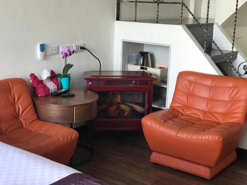 a living room with two chairs and a fireplace at SunSweet House in Fanlu