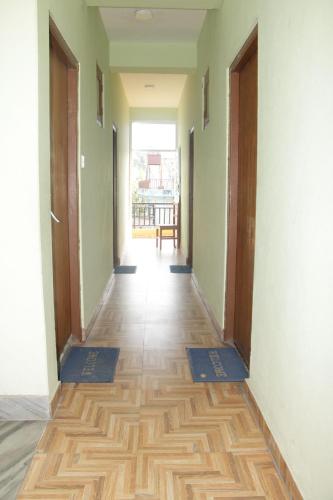 a hallway with two doors and a wooden floor at Harry Guest House & Restaurant in Pokhara