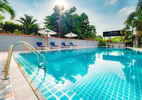 a pool at a hotel with chairs and umbrellas at Chabana Resort Bang-tao Beach Phuket- SHA Extra Plus in Bang Tao Beach