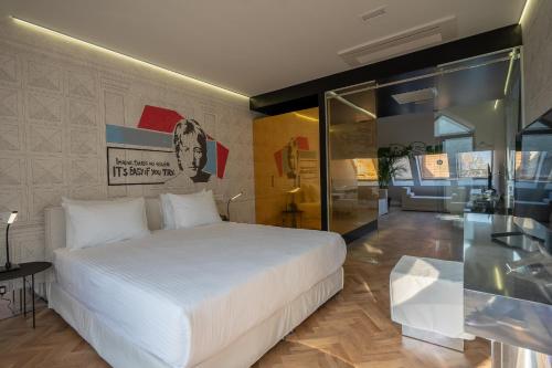 a bedroom with a white bed and a wall at Platforma Design Hotel in Tbilisi City