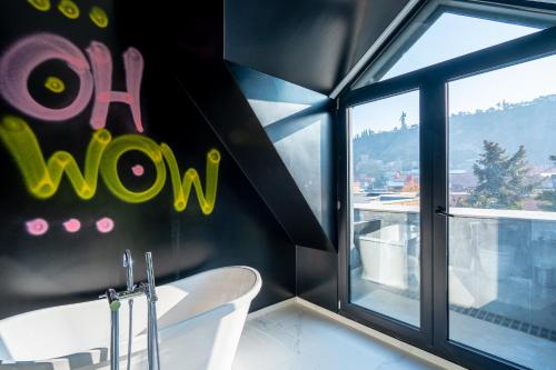a bathroom with a white tub and a window at Platforma Design Hotel in Tbilisi City