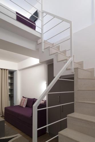 a loft bed with a staircase in a room at Olympos Suites Apartments in Leptokaria