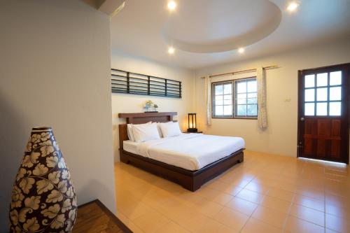 a bedroom with a bed and a lamp in it at Surin House in Surin Beach