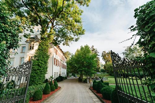 eine Auffahrt, die zu einem Haus mit einem Zaun führt in der Unterkunft Welcome Hotel Schloss Lehen in Bad Friedrichshall