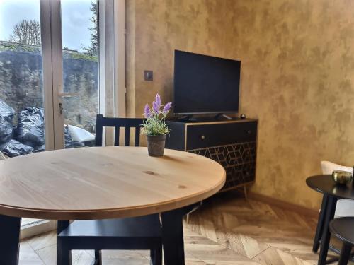 een eetkamer met een tafel en een tv bij Le Mangin - Studio avec terrasse in Metz