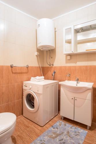 a bathroom with a washing machine and a sink at Bologna Apartments in Budva