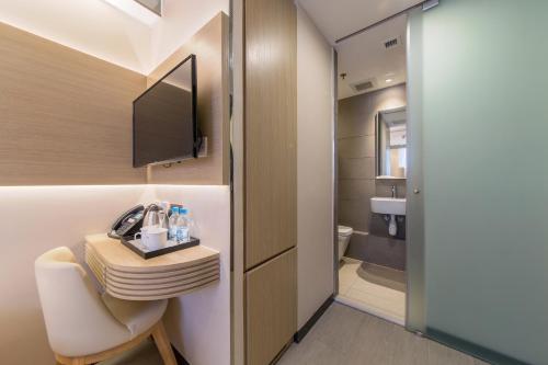 een kleine badkamer met een wastafel en een toilet bij Lumine Hotel in Hong Kong