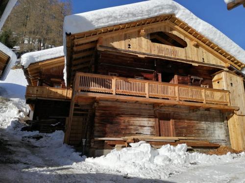 ein Blockhaus mit Schnee seitlich in der Unterkunft Almhütte Senfter in Innervillgraten