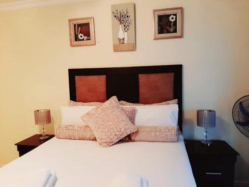 a bedroom with a white bed with pillows on it at 40 La Mer, Illovo Beach Apartment in Amanzimtoti