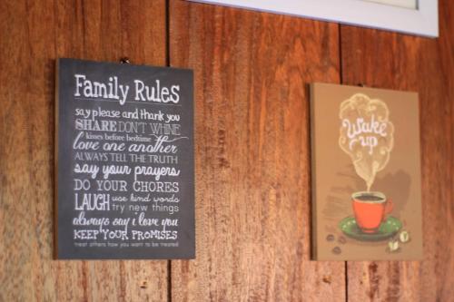 a sign on a wall with a cup of coffee at Oemah Kajoe Lembang in Lembang