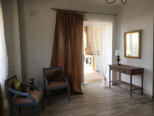 Cette chambre dispose de deux chaises, d'un bureau et d'une fenêtre. dans l'établissement Elafonisi Villa above the Beach, à Elafonisi