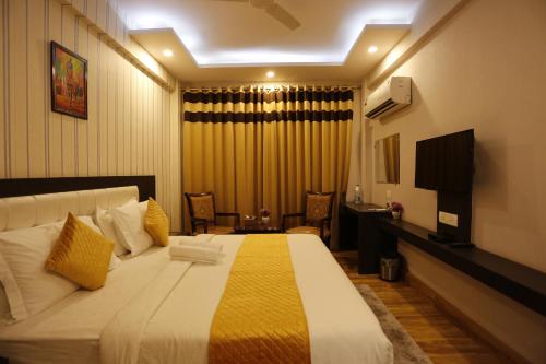 una camera d'albergo con un letto e una televisione di Paradise Ganga - A River Side Hotel a Rishikesh