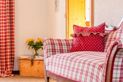 a red and white plaid couch with red and white pillows at Haus Leiter in Reit im Winkl