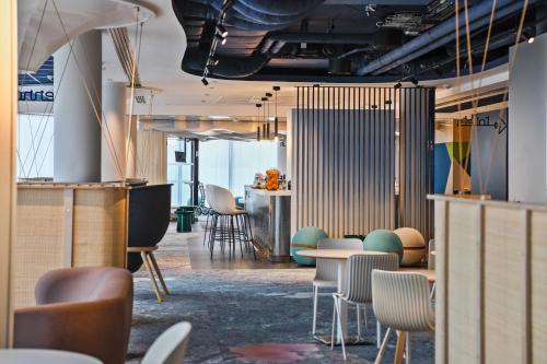 a room with tables and chairs and a counter at ibis Styles Paris Orly Airport in Paray-Vieille-Poste