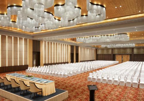 an empty banquet hall with white tables and chairs at Taj Agra in Agra