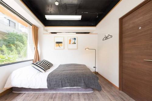 a bedroom with a bed and a large window at TORA HOTEL Tokyo-Rikugienn 寅ホテル 六義園 A in Tokyo