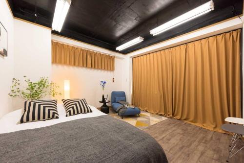 a bedroom with a large bed and a chair at TORA HOTEL Tokyo-Rikugienn 寅ホテル 六義園 A in Tokyo