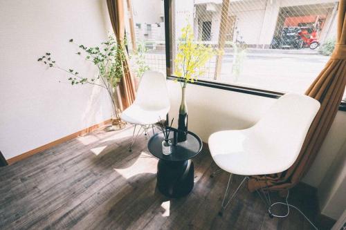 a room with three white chairs and a window at TORA HOTEL Tokyo-Rikugienn 寅ホテル 六義園 A in Tokyo