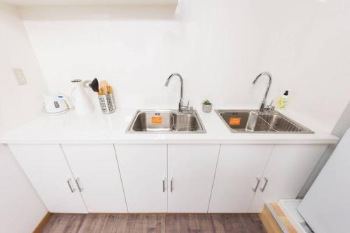 a kitchen with white cabinets and two sinks at TORA HOTEL Tokyo-Rikugienn 寅ホテル 六義園 A in Tokyo