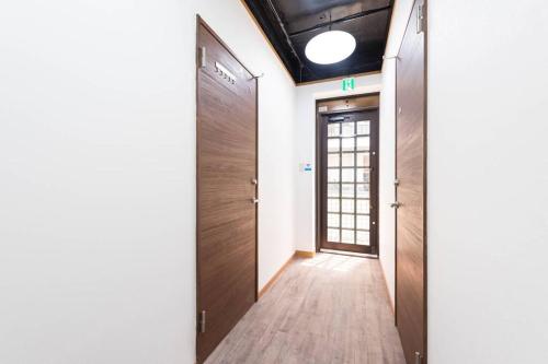 a hallway with two wooden doors and a hallway with a hallway at TORA HOTEL Tokyo-Rikugienn 寅ホテル 六義園 A in Tokyo