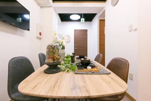a wooden table with chairs and a vase on it at TORA HOTEL Tokyo-Rikugienn 寅ホテル 六義園 A in Tokyo
