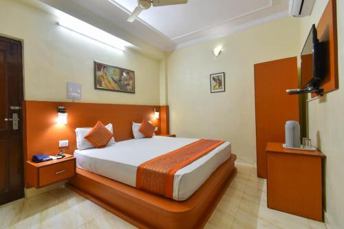 a bedroom with a bed and a flat screen tv at Hotel Jaisingh Palace in Jaipur
