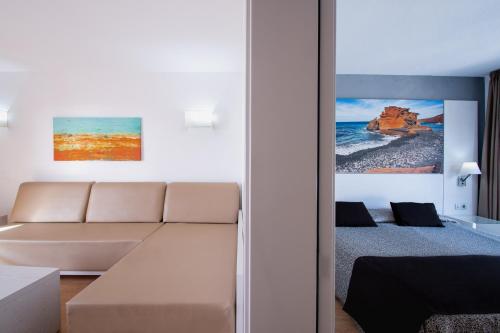 een woonkamer met een bank en een bed bij HL Paradise Island in Playa Blanca