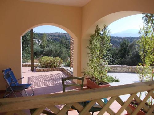 Pokój z 2 krzesłami i balkonem z widokiem na okolicę. w obiekcie Marilena Apartment Olive Tree w mieście Gavalochori